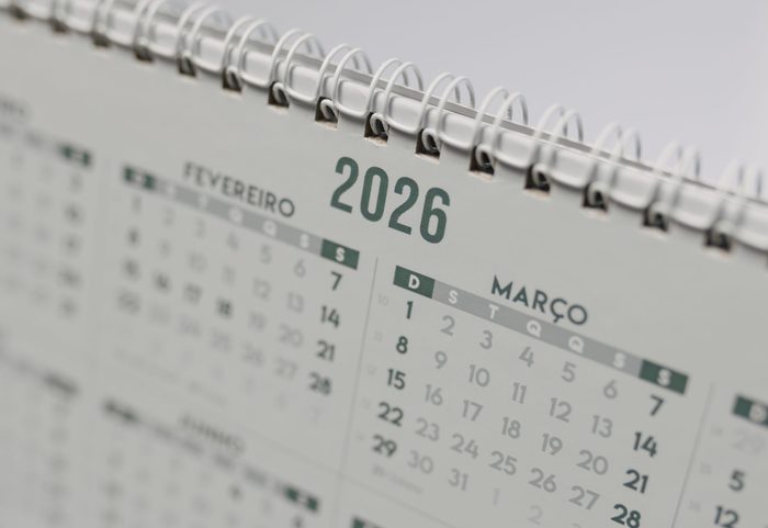 Wandkalender mit Wire-O-Bindung und Aufhängebügel auf einem Arbeitstisch – Kalenderkonfektion bei APOOL WERKE